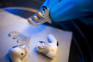 The screen-printed, flexible sensors are attached to the earbuds on a flexible, stamp-like surface.