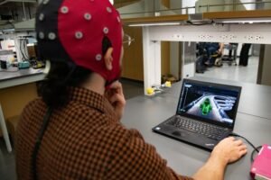 Hussein Alawieh, a graduate student in José del R. Millán's lab, wears a cap packed with electrodes that is hooked up to a computer. The electrodes gather data by measuring electrical signals from the brain, and the decoder interprets that information and translates it into game action.