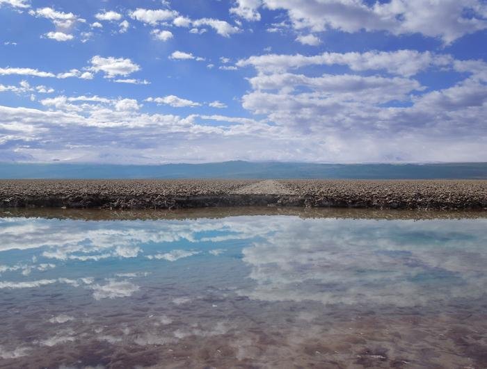 An abandoned road and brine transitional pool at the margin of the Salar de Atacama Halite Nucleus.